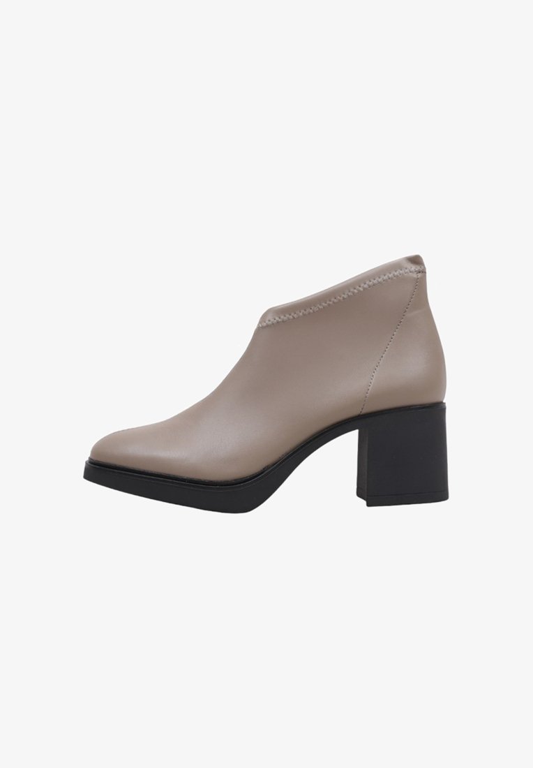Beige Lederstiefelette mit einer spitzen Zehe, kontrastierendem schwarzem Blockabsatz und einer dezenten Naht entlang der oberen Kante.