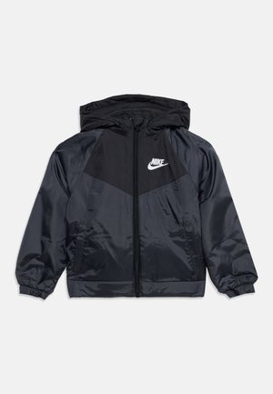 Sort og mørkegrå Nike hættejakke med lynlås foran og hvid Nike-logo på venstre bryst.