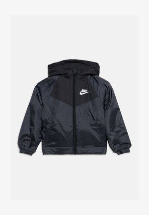 Mustast ja tumedast hallist Nike kapuutsiga tuulejope esiluku ja valge Nike logoga vasakul rinnal.