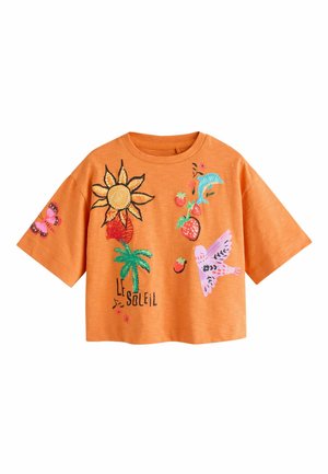 Orange kortærmet skjorte med farverig sol, palme, jordbær, delfin, fugl, sommerfugl og teksten "Le Soleil" på fronten og ærmet.