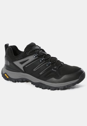Scarpa da trail running nera con accenti grigi, materiale in rete e sintetico, suola texturizzata e marchio Vibram. Presenta una costruzione durevole e un sistema di allacciatura.