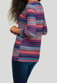 Maglione a maniche lunghe multicolore con motivo a zigzag in tonalità di rosa, blu e viola. Presenta un collo rotondo e una vestibilità comoda.
