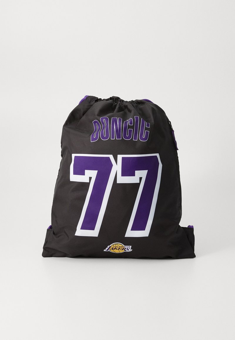 Čierny batoh na sťahovanie so bielymi číslami "77" a "DONCIC" v purpurovej farbe, s logom Lakers na dne. Vyrobený z odolnej tkaniny.