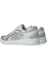 Paire de chaussures de course athlétiques grises et blanches avec des superpositions en mesh et synthétiques, vues de dos et de côté sur un fond blanc.