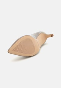 Gray pointed-toe heel with a textured fabric upper and smooth, light brown sole featuring horizontal grip lines. Heel height not visible.