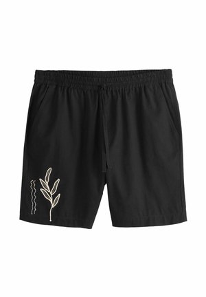 Schwarze Shorts mit elastischem Bund, Seitentaschen und weißer Blätterstickerei am linken Bein nahe dem Saum.