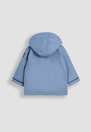 Lysblå vandtæt jakke med hætte, der har lange ærmer og en sort stribet detalje ved manchetterne. Glat tekstur, minimalistisk design.