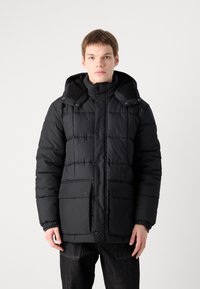 Black puffer jacket featuring a zip and button front closure, two large front pockets, and a hood with a textured lining.