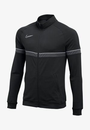 Schwarze Nike Sweatjacke mit Reißverschluss, mit weißem Streifen über Brust und Armen, versehen mit dem Nike-Swoosh-Logo auf der rechten Brust.