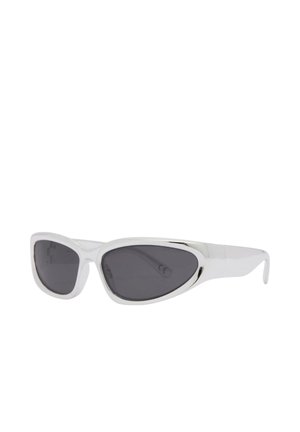 Lunettes de soleil à monture blanche avec des verres ovales étroits, noirs et asymétriques, présentées en angle trois-quarts sur fond blanc.