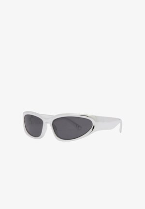 Lunettes de soleil à monture blanche avec des verres ovales étroits, noirs et asymétriques, présentées en angle trois-quarts sur fond blanc.