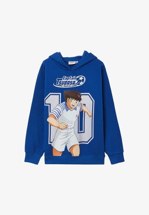 Felpa blu con logo "Captain Tsubasa", grande numero 10 e calciatore animato in azione che indossa un'uniforme bianca con patch della bandiera giapponese.