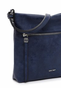 Borsa in pelle perforata blu navy con tracolla liscia e dettagli in cerniera argentata, caratterizzata da un logo sulla parte anteriore inferiore e una forma strutturata.