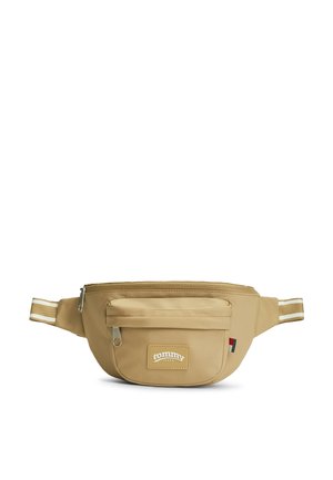 Beige Tommy Jeans bæltetaske med stribet justerbar rem, front lynlåslomme og logo-patch på frontlommen.