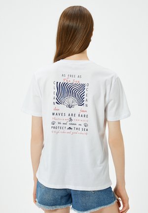 Hvid bomulds T-shirt med et farverigt grafik på ryggen med havrelateret tekst og et skalkoncept, kortærmet og med en afslappet pasform.