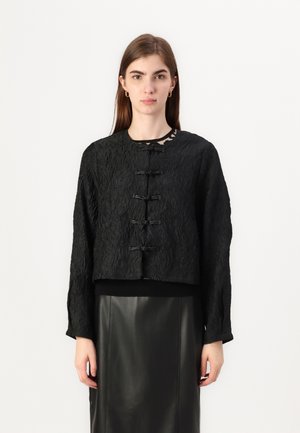 Black cropped jacket with textured fabric, featuring a round neckline, long sleeves, and five toggle fastenings at the front.