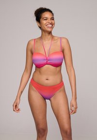 Twee-delige bikini met een roze naar paarse gradient design. De top heeft een gedraaide voorkant met dunne bandjes, en de broekjes zijn low-rise.