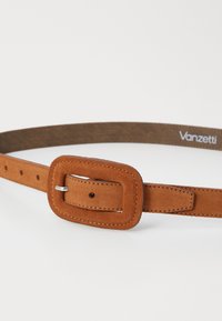Tan suede belt with a rectangular, textured buckle. Features adjustable holes and contrasting stitching on a smooth back. Brand logo visible.