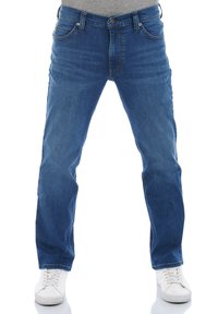 Jeans de mezclilla azul con un corte de pierna recta. Las características incluyen cinco bolsillos, una cremallera y detalles de costura. Combinados con zapatillas blancas.