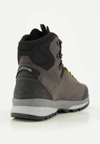 Stivale da trekking grigio con suola in gomma resistente, tomaia in camoscio, dettagli in rete nera e lacci gialli. Presenta occhielli in metallo e un colletto imbottito.