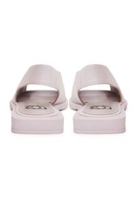 Sandale din piele roz, cu talpă plată, design cu vârf deschis și detalii cu curea curbată. Textură netedă și siluetă minimalistă.