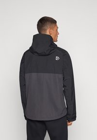 Water-resistant jacket in black and grey, featuring a hood, elastic cuffs, and a logo on the back. Soft texture with a streamlined design.