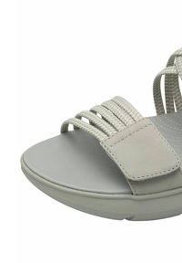 Sandal grigio chiaro con una larga cinturino e cinque cordini elastici, suola interna testurizzata e suola piatta. Realizzato in materiale sintetico.