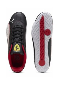Musta synteettinen päällinen punaisilla yksityiskohdilla, valkoinen pohja, kuvioitu kuvio, Puma-logo ja Ferrarin tunnus kielen kohdalla. Nauhallinen malli, matala leikkaus.
