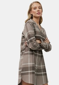 Camicia a quadri lunga in tonalità beige e marrone, realizzata in tessuto morbido con bottoni sul davanti, maniche lunghe e orlo curvo.