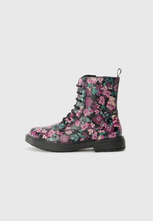Florale Kampfstiefel mit glänzender schwarzer Oberfläche, versehen mit rosa und grünen Blumenmustern, einer runden Zehenpartie und strapazierfähigen schwarzen Gummisohlen.