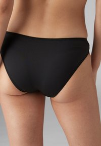 Crni bikini donji dio izrađen od glatkog materijala s umjerenim usponom, koji ima tanki elastični pojas i bez vidljivih uzoraka ili hardvera.