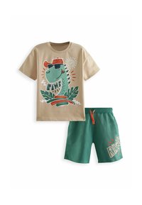 Beige bomulds T-shirt med dino grafik, shorts i grøn med snøre og hvide detaljer, med teksten "RAWR".
