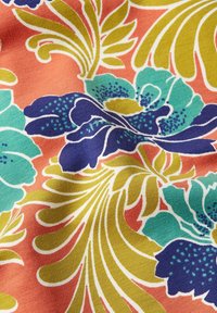 Tkanina z żywym kwiatowym wzorem zawierająca turkusowe, granatowe i żółte kwiaty na koralowym tle, z widocznym splotem. 