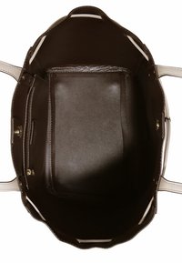 Wnętrze brązowej skórzanej torby na ramię o gładkiej fakturze, z kieszonką na zamek błyskawiczny i jasnymi akcentami wzdłuż brzegów.