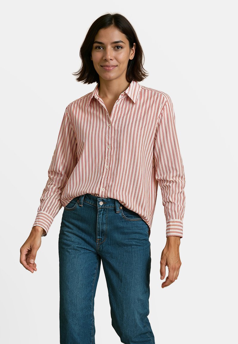 Rood-wit gestreepte overhemd met lange mouwen, gecombineerd met high-waisted blauwe jeans. Gladstof, klassieke kraag en knoopdetails.