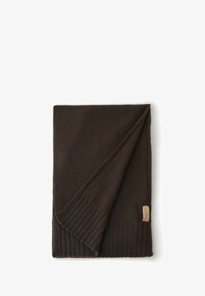 Donkerbruin gebreide deken met een geribbelde rand. Zachte textuur, met een gevouwen hoek en een klein merketiket aan de zijkant.