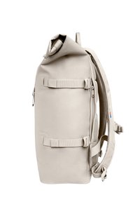 Beige rulle-top rygsæk med justerbare stropper, netpolstring på ryggen, to vandrette kompressionsstropper og sidelomme med lynlås.