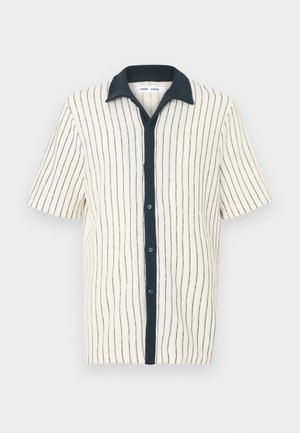 Kortærmet skjorte med lodrette sorte striber på cremefarvet stof, sort krave og sort knaplukning foran.