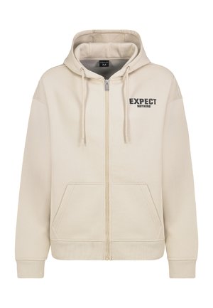 Beige Kapuzenpullover mit Reißverschluss, Kordelzugkapuze, Fronttaschen und dem Aufdruck "EXPECT NOTHING" in Schwarz auf der linken Brustseite.