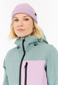 Voděodolná bunda v tlumené modrozelené barvě s jasně růžovým předním panelem; obsahuje kapuci, zip a nastavitelné šňůrky.