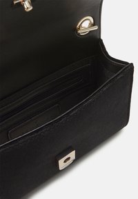 Black fabric wallet with a smooth texture, featuring a gold-tone hardware clasp and an interior zip pocket for organization.