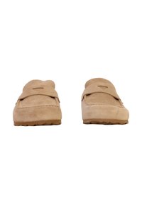 Beige suede moccasin slippers with a rounded toe, stitched detailing, and rubber soles. Features a decorative strap across the front.