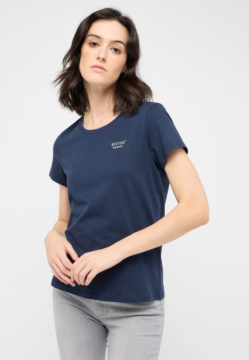 Navyblaue Kurzarm-T-Shirt aus Baumwolle mit Rundhalsausschnitt und kleinem weißen "MUSTANG ORIGINAL" Logo auf der Brust.