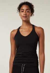 Top senza maniche di colore nero con scollo a V, realizzato in tessuto morbido. Presenta sottili spalline con logo e una silhouette aderente.