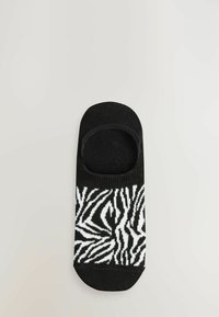 Șosetă de gleznă cu dungi alb-negru, cu un design cu croială joasă, având un model de zebră pe talpă și o textură netedă.