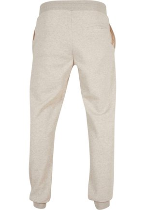 Pantaloni tuta beige realizzati in cotone morbido, con vita a coste, polsini elastici, tasche laterali e una singola tasca posteriore.