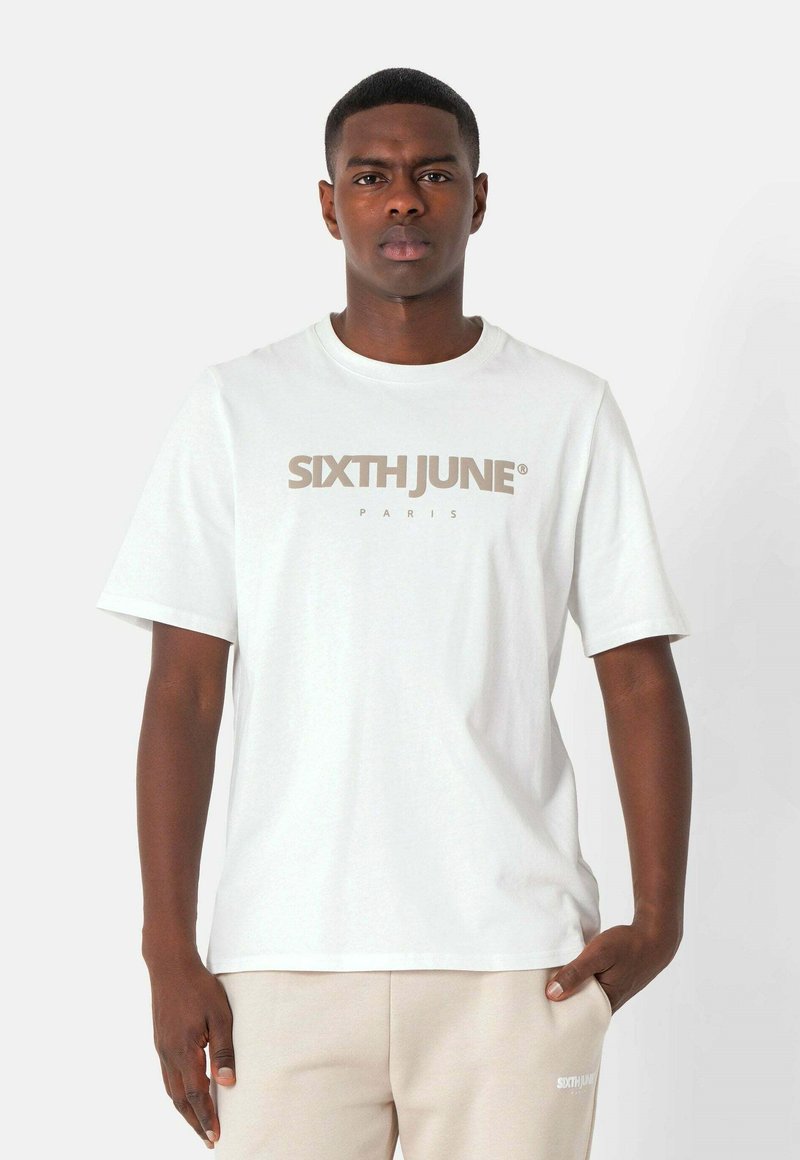 Hvid bomulds t-shirt med rund hals og korte ærmer, med teksten "SIXTH JUNE PARIS" trykt i beige over brystet.