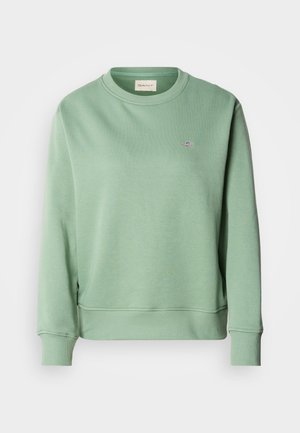 Mintgrønn genser med rund hals, lange ermer, ribbede mansjetter og kant. Har et lite brodert logo på brystet.