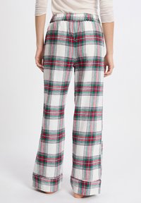 Gestreepte loungebroeken in wit, rood, groen en grijs. Zachte stof, relaxte pasvorm met een elastische tailleband en opgerolde manchetten aan de zoom.