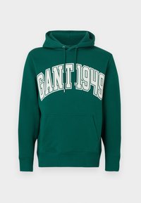 Sudadera verde con capucha y bolsillo canguro delantero, con el texto "GANT 1949" en grandes letras blancas en el pecho. Capucha con cordón ajustable.